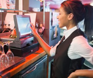 Woman employee in hospitality using an EPOS system